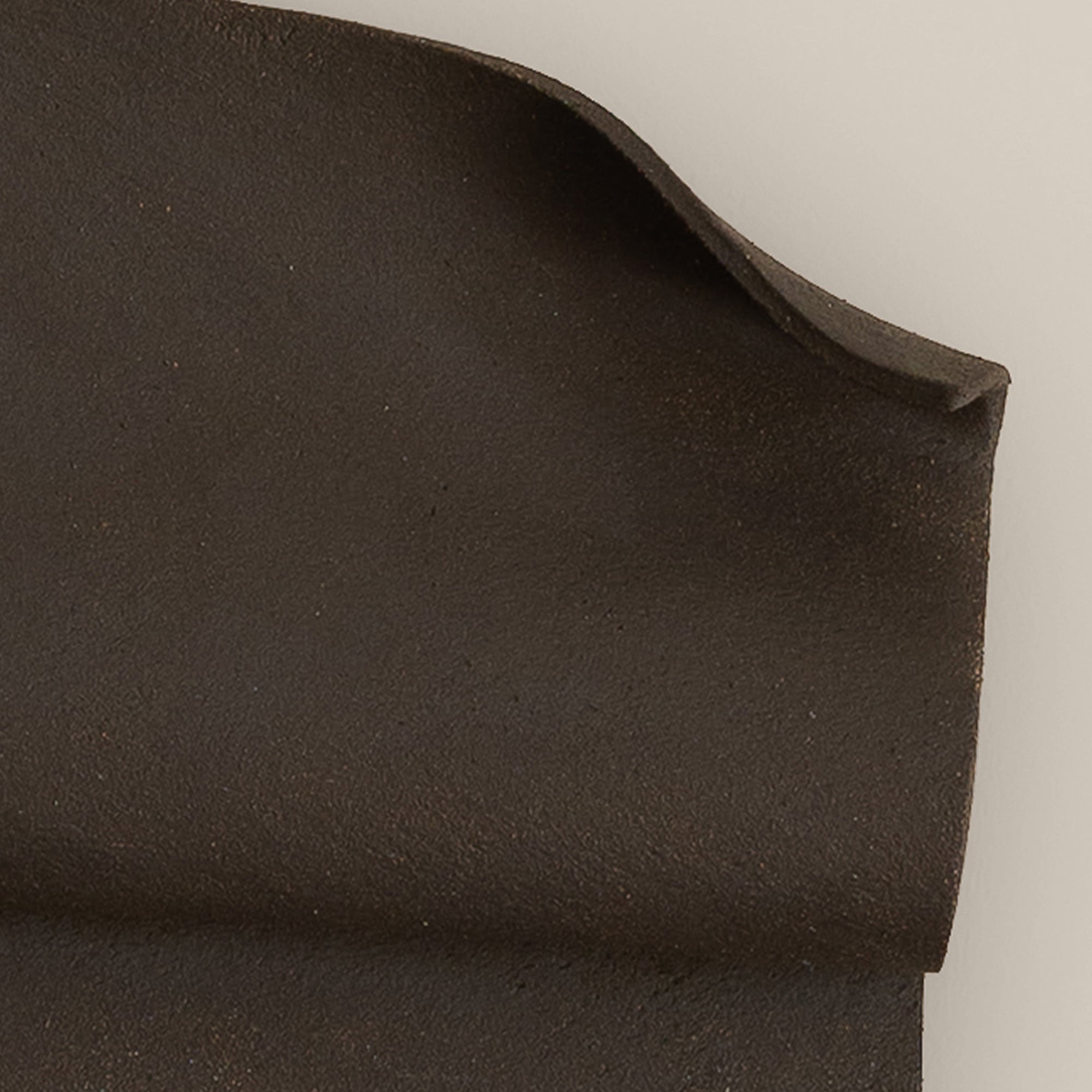 Writings 001 by Studio JOA — close-up of the folded curl in Dark Brown stoneware, showing the hand-brushed surface texture
