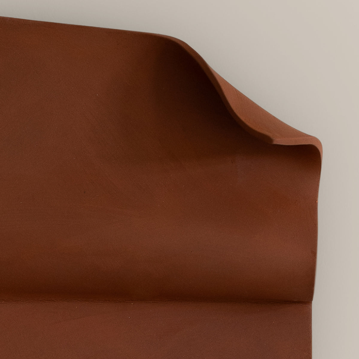 Writings 001 by Studio JOA — close-up of the folded curl in Stone Red stoneware, showing the hand-brushed surface texture