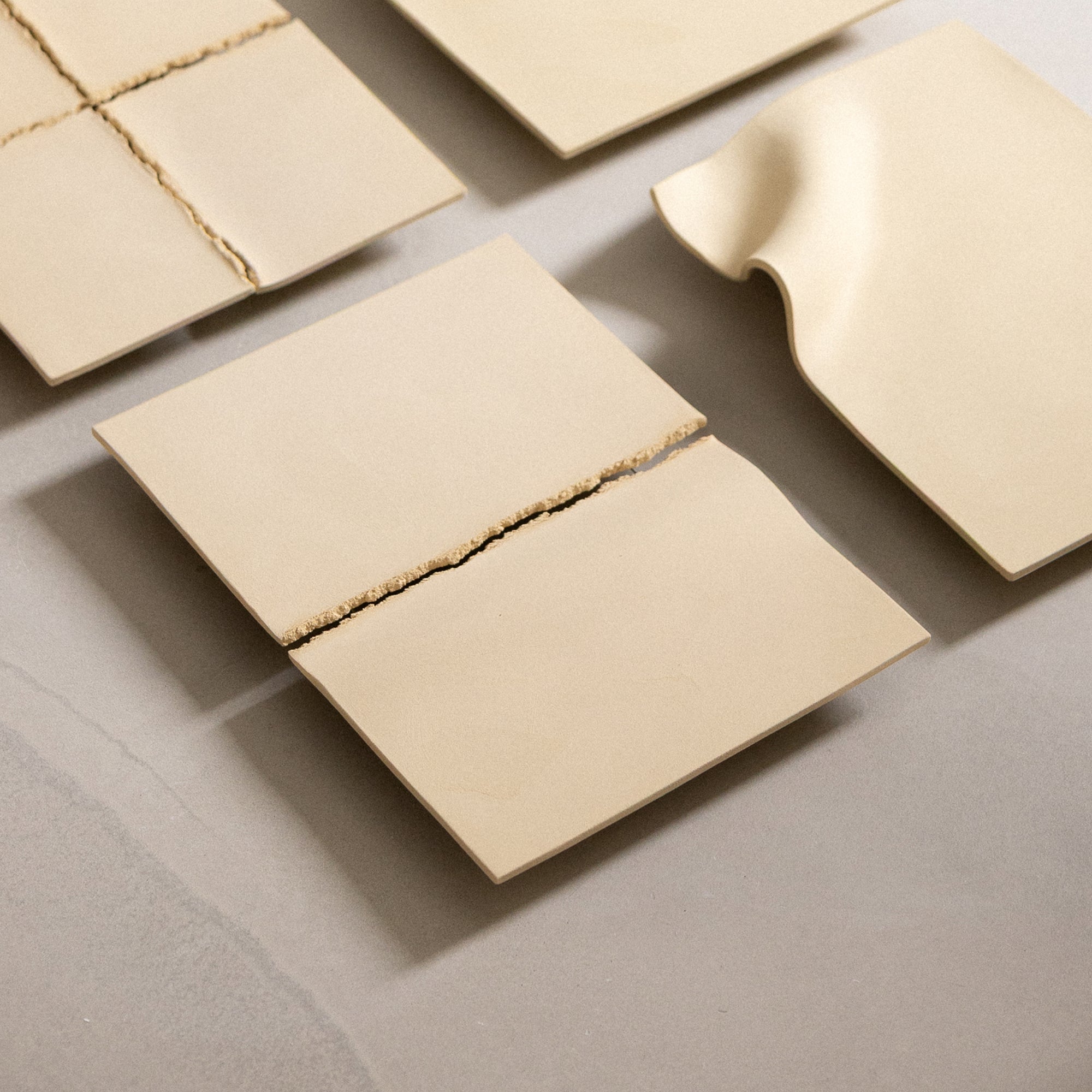 Studio JOA — Butter Yellow stoneware wall piece in the studio, resting on a table beside other Writings pieces