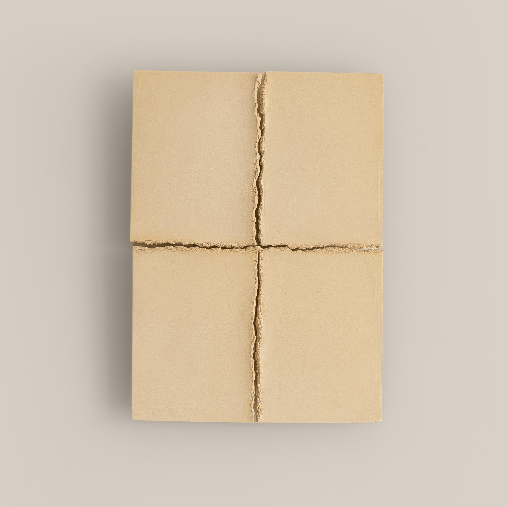 Writings 004 by Studio JOA — Butter Yellow stoneware wall piece divided into four panels by a cross-shaped seam, photographed against a plain wall
