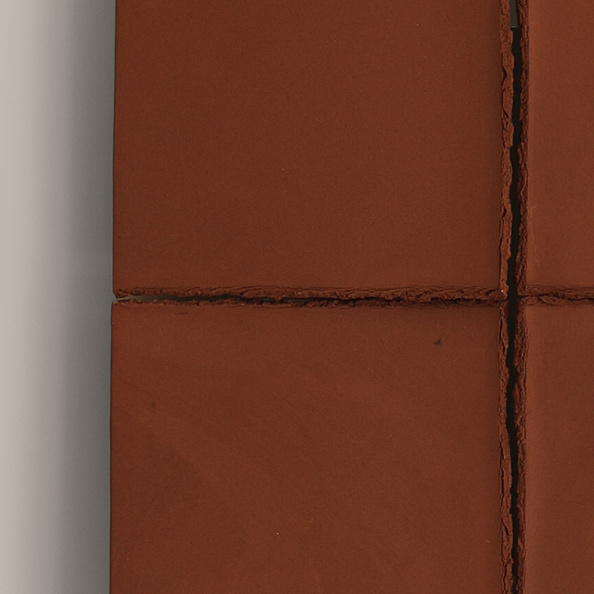 Writings 004 by Studio JOA — close-up of the cross-shaped seam in Stone Red stoneware, showing the hand-brushed surface texture
