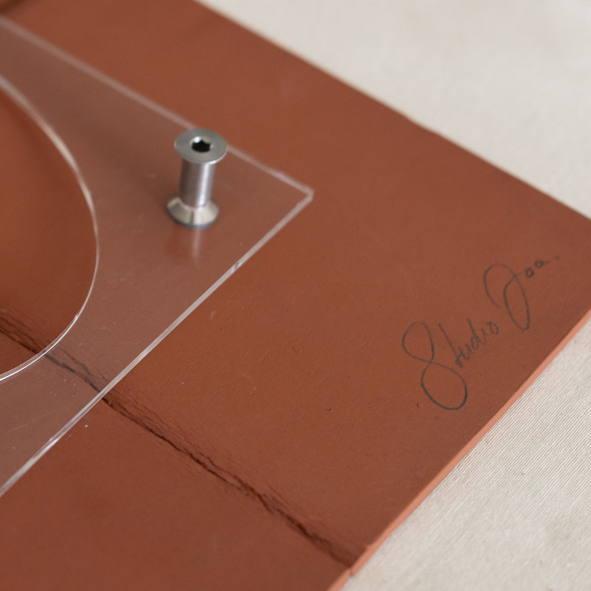 Writings 004 by Studio JOA — back of the Stone Red stoneware wall piece, showing the hand-signed 'Studio JOA' mark and mounting hardware