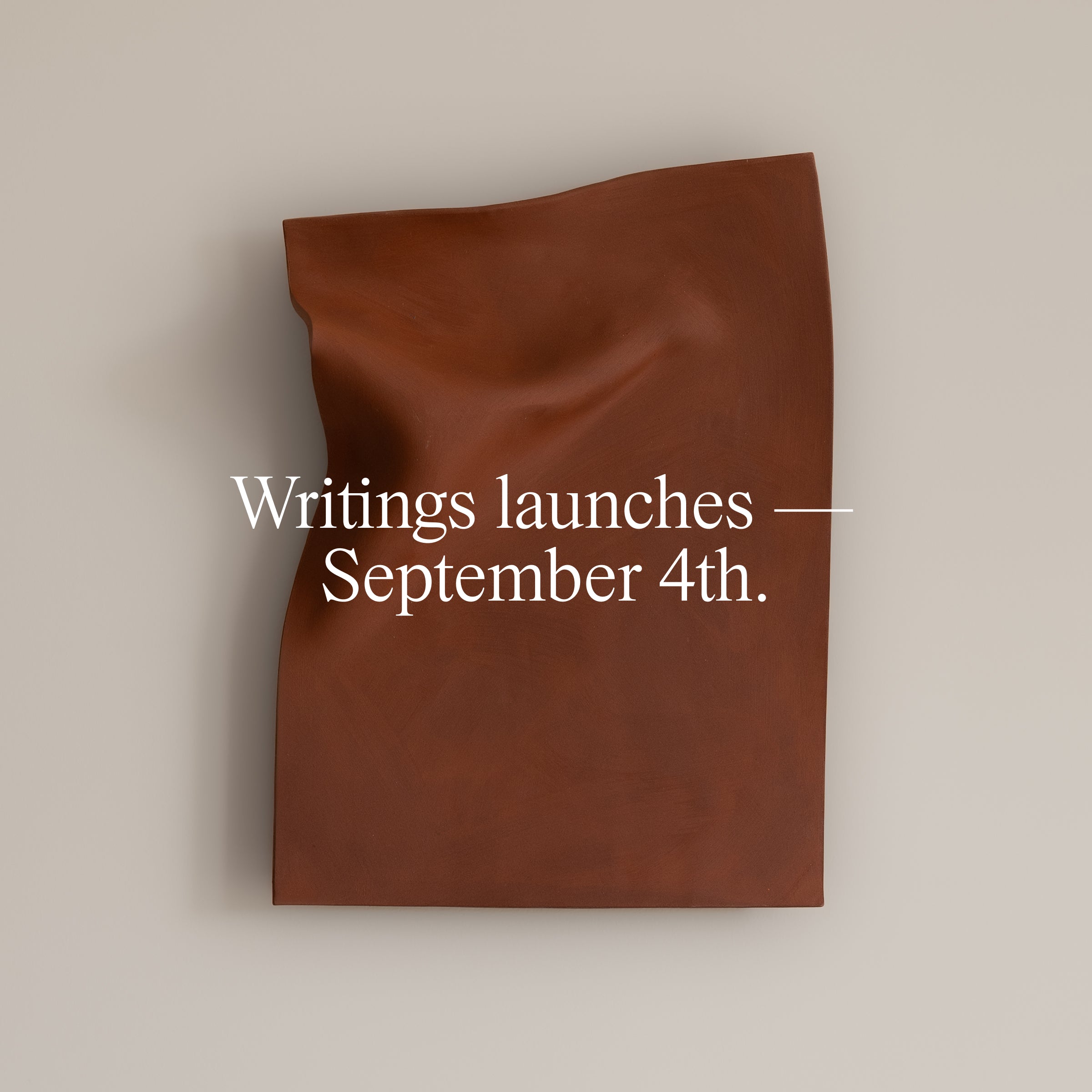 Writings launches September 4th — Stone Red folded ceramic wall piece by Studio JOA, mounted on a plain wall, coming soon